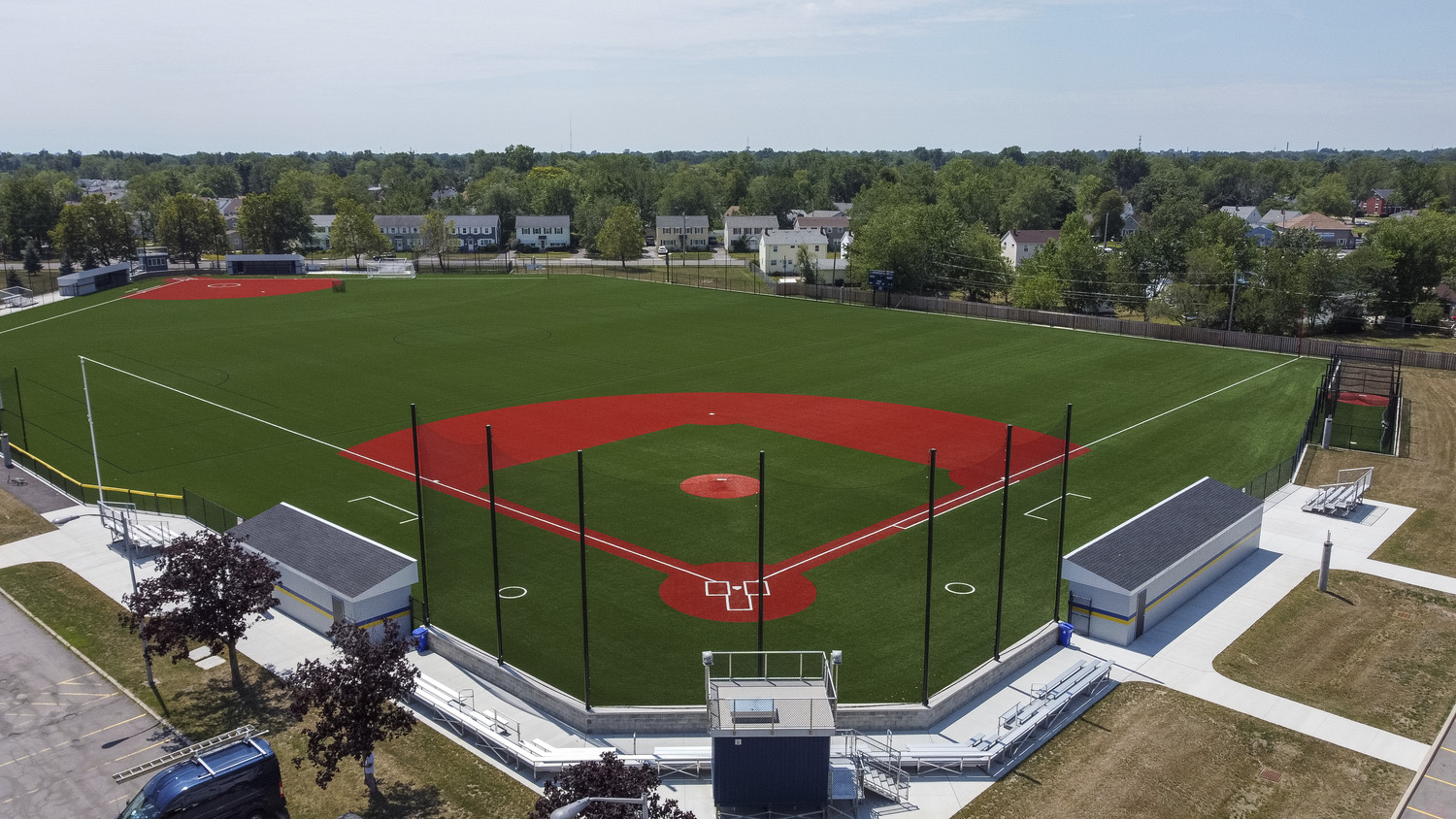 Overall view of Kenmore-East High School athletic fields including a softball field, dugouts, lighting, viewer box, paving.