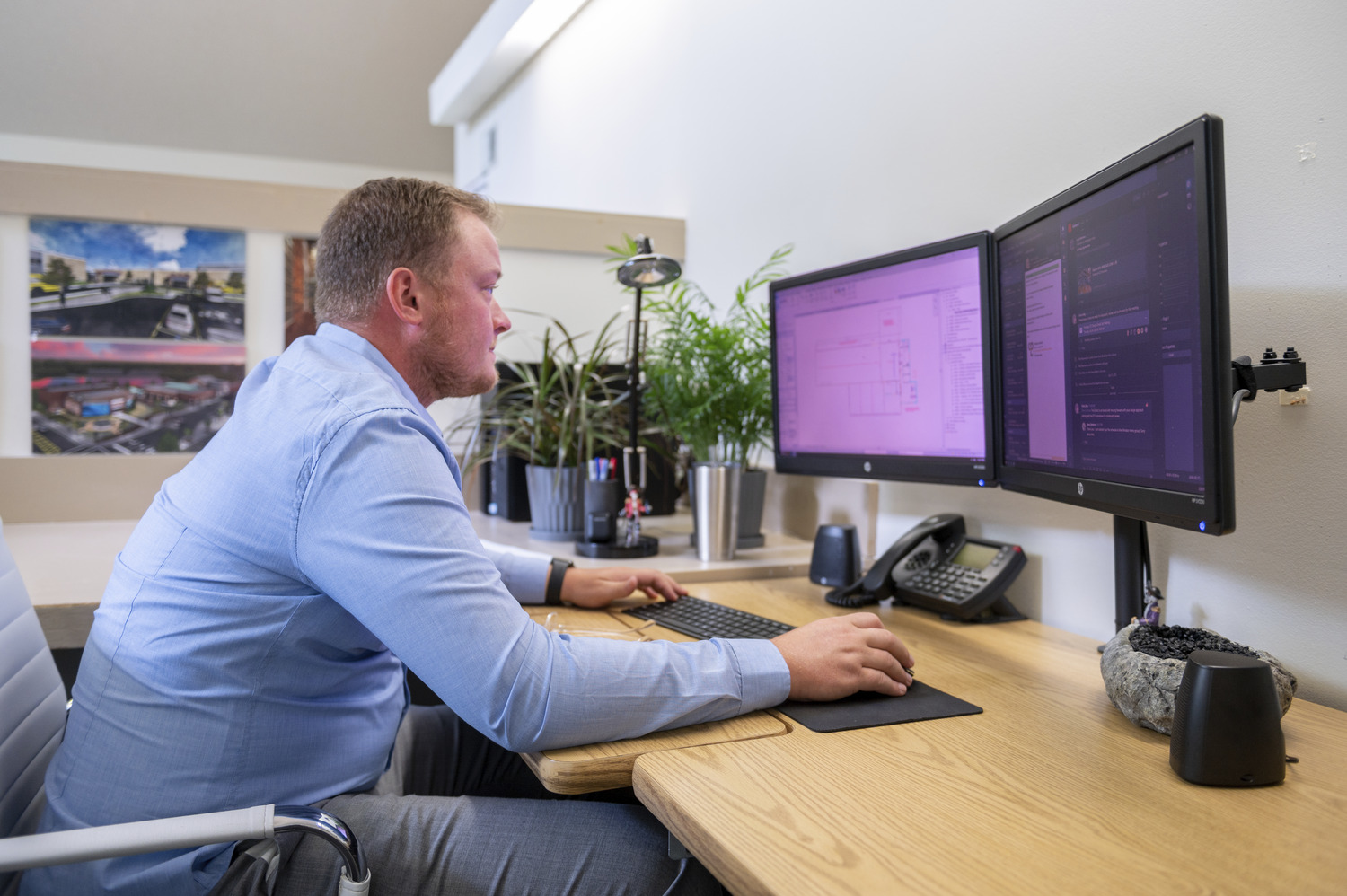 A man looking at two computer screens.