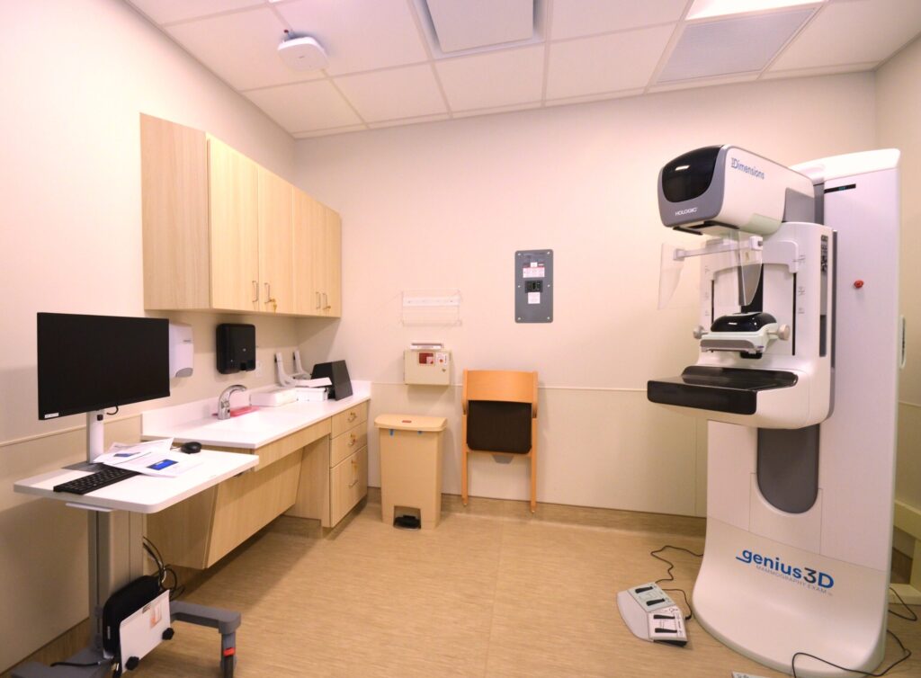 the interior of a patient room with medical equipment, monitors and cabinets.