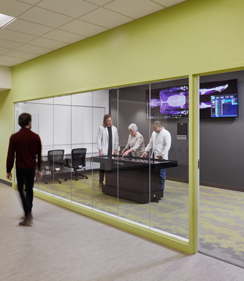 Medical students practicing with high-fidelity manikins in a hospital-like simulation room with medical equipment on Union Square Campus.