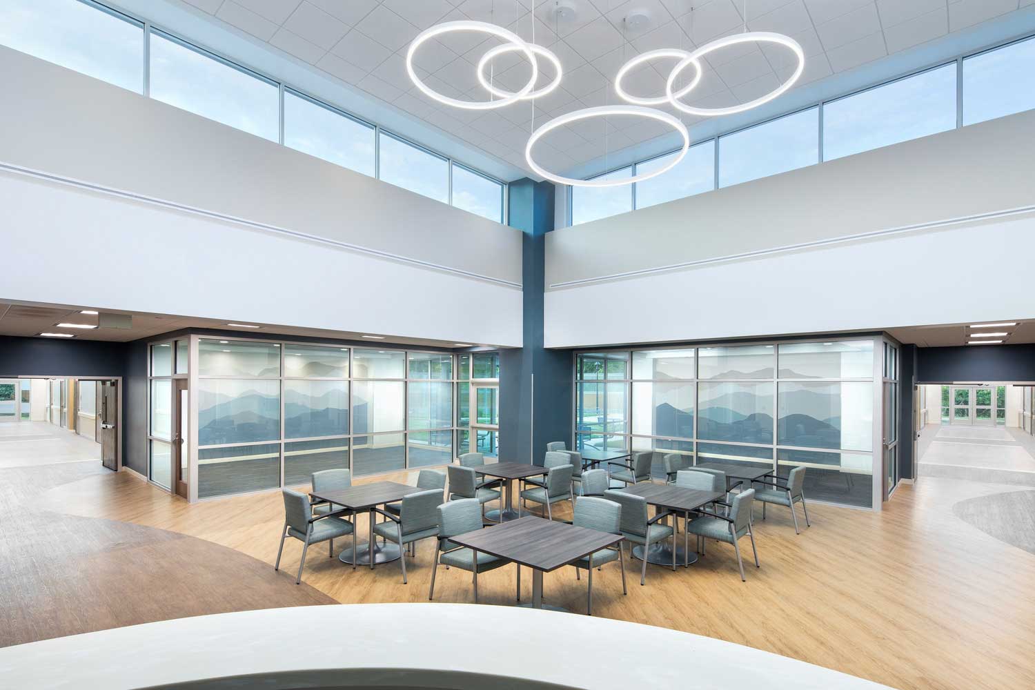 Image shows Design for the 21,680 sq. ft. Jonas Hill Hospital and Behavioral Health Clinic in Lenoir, NC, emphasizes community awareness and patient dignity. Lighting design provides a pleasing, non-institutional atmosphere for patients, while the layout features soft hues and natural wood accents that align with tranquil theming intentions.