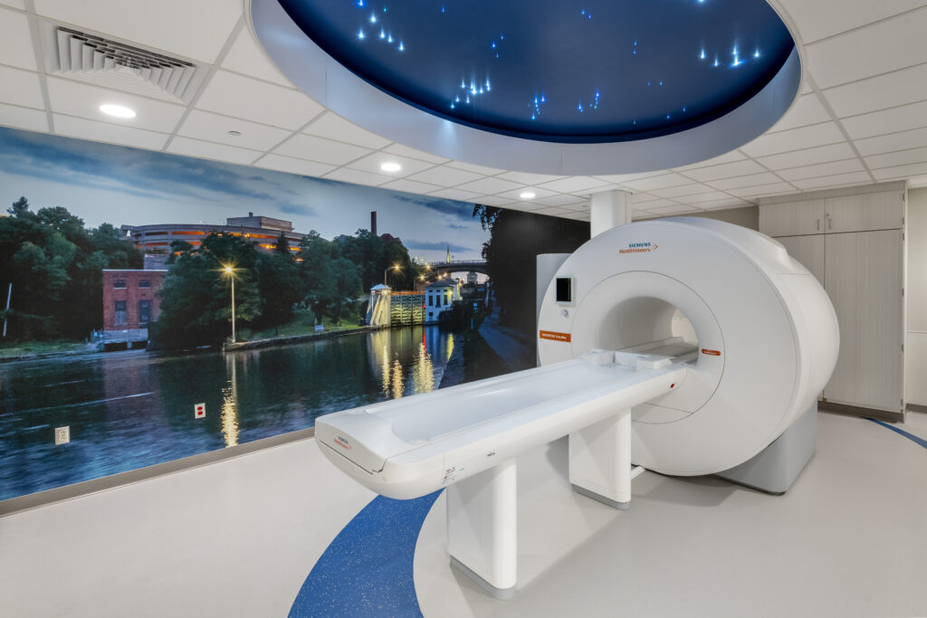 Lockport Memorial Hospital CT machine in a room with scenic wall coverings and blue ceiling