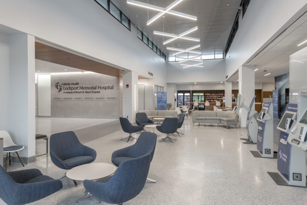 Lockport Memorial Hospital Interior hospital lobby with tables, blue chairs and couches, and kiosks for self-check-ins