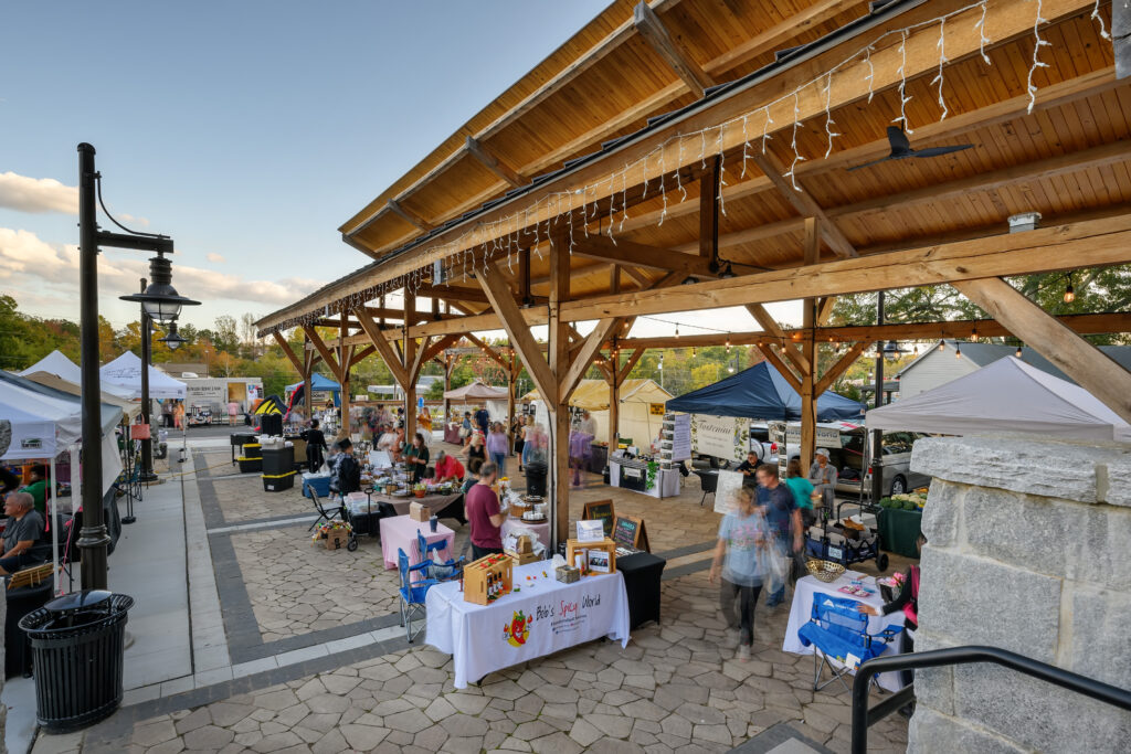 Flowery Branch Farmers Market with people shopping under pavilion with lights and wood panels
