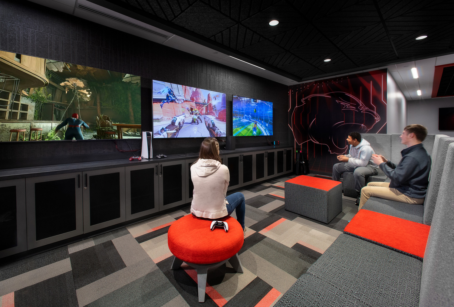 A group of students playing video games in a modern eSports suite's casual gaming area.