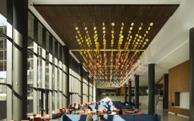Common area with people, warm colored light fixture and window wall