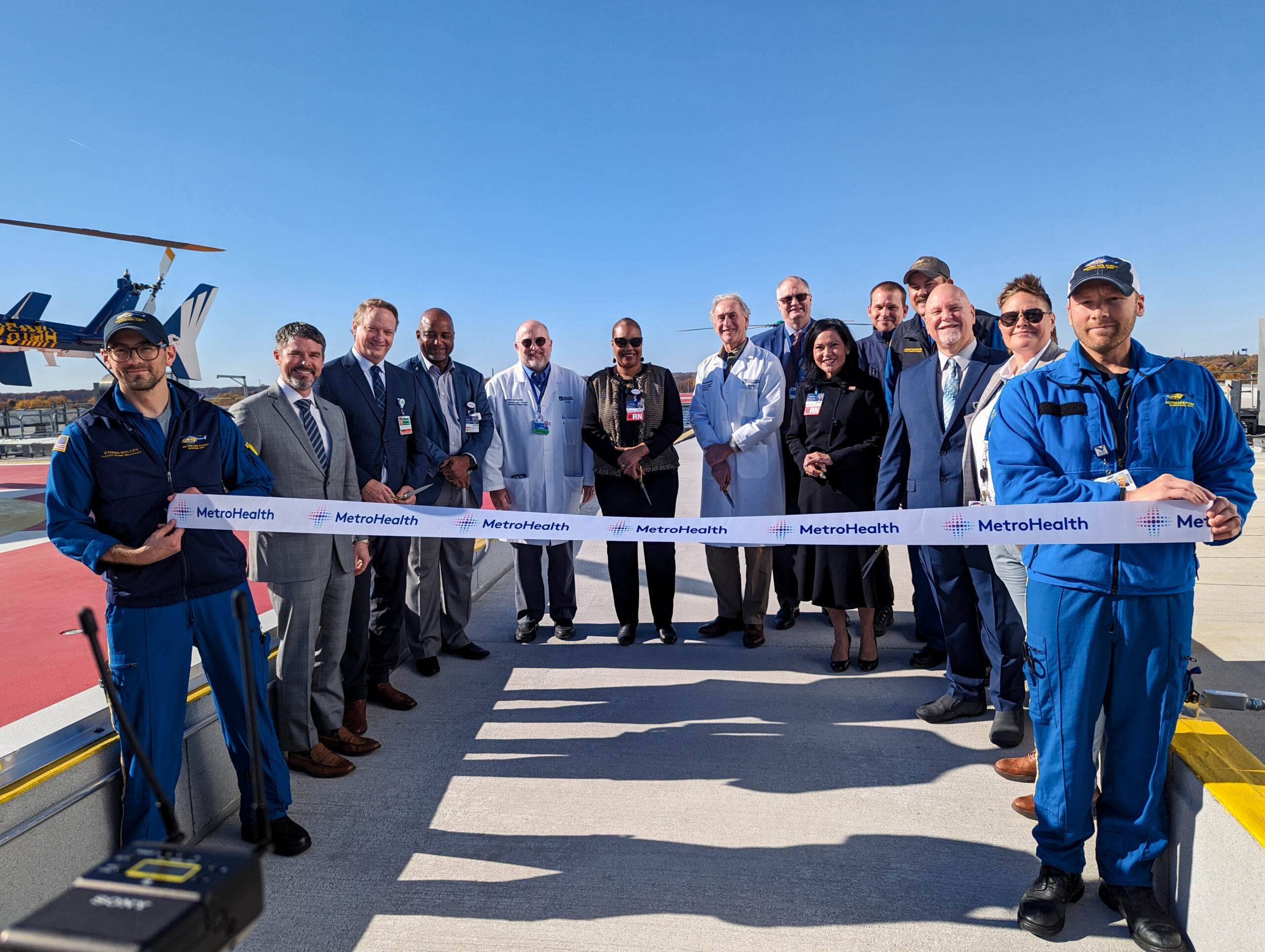 MPA_2022_002_MetroHealth_CCP_N5 Ribbon cutting at MetroHealth Critical Care helipad with pilots, doctors, and hospital executives smiling