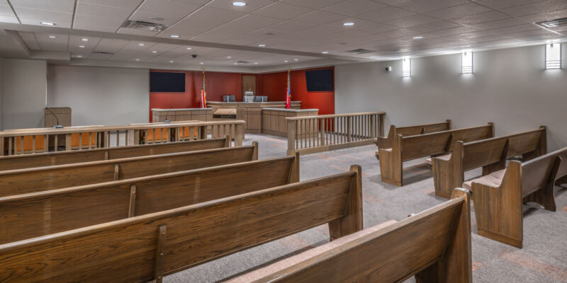 Courtroom with long wooden benches and orange accent wall