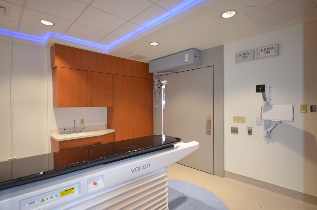 The slab and the far end of the treatment room, showing the cabinets, counter, sink and a large grey door.