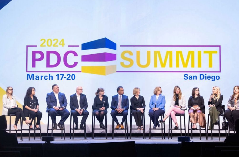 A group of people sitting on a panel at the annual PDC Summit.