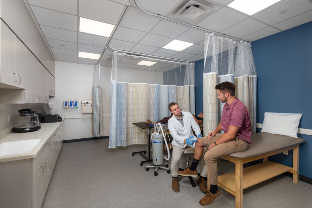 Orthopedic medical exam room where a doctor is examining a patient knee