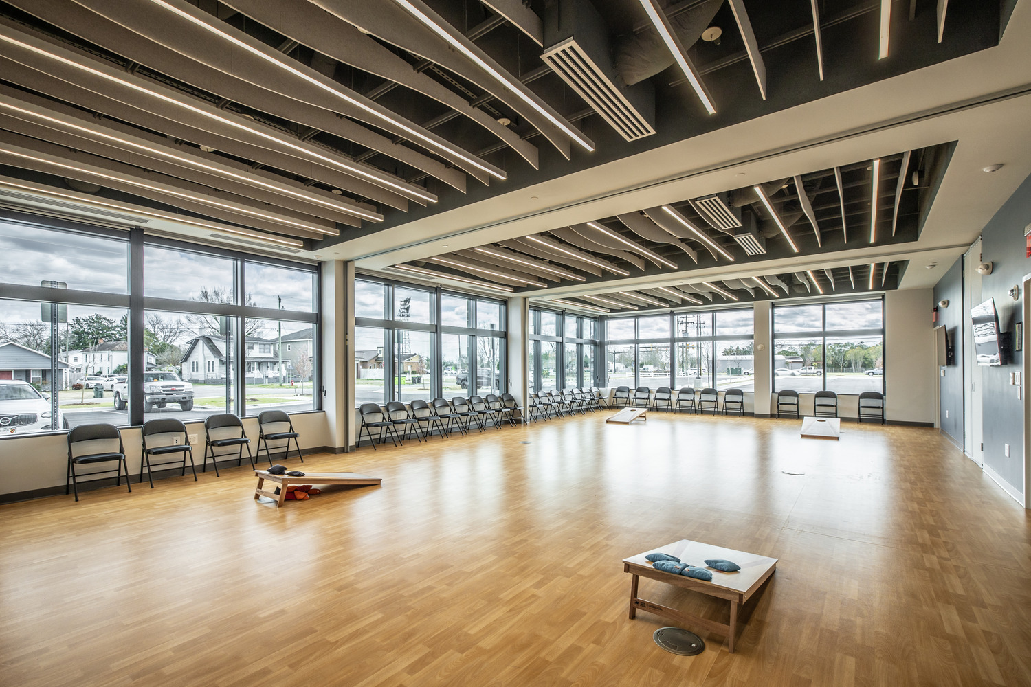 A spacious room inside Stanley A. White Recreation Center with two games of cornhole set up.