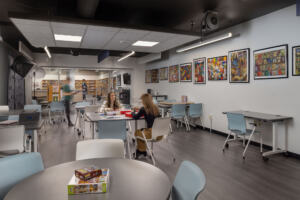 The improved makerspace at Odyssey High School with walls decorated with colorful student artwork.