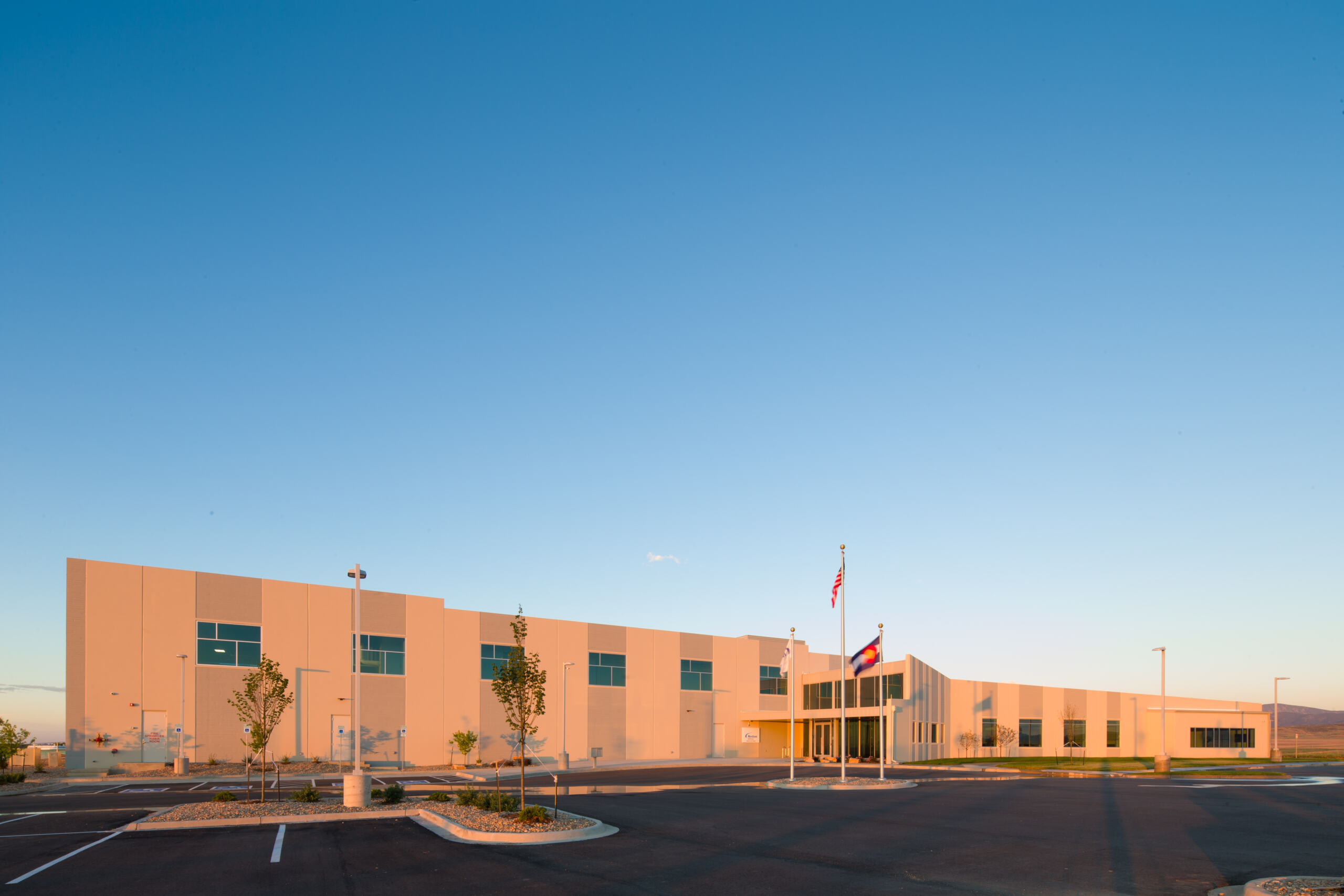 view of a building with flags in front of it at sunset