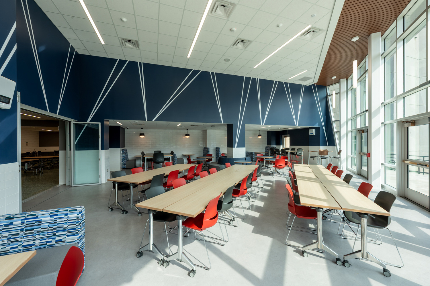 Another view of the Southwestern Central High School cafeteria interior, long tables, and dark blue drop ceilings with striking white lineart. This was part of the Southwestern Central School District Capital Improvements