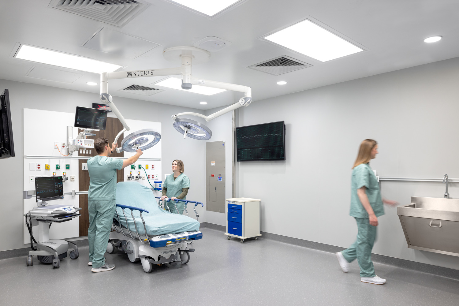 An intake space within the tower's emergency department, a patient bed with medical equipment, and several healthcare workers doing tasks.