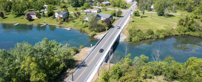 Cars pass over the Alexandria Avenue bridge, which transitions seamlessly into the rest of the avenue.
