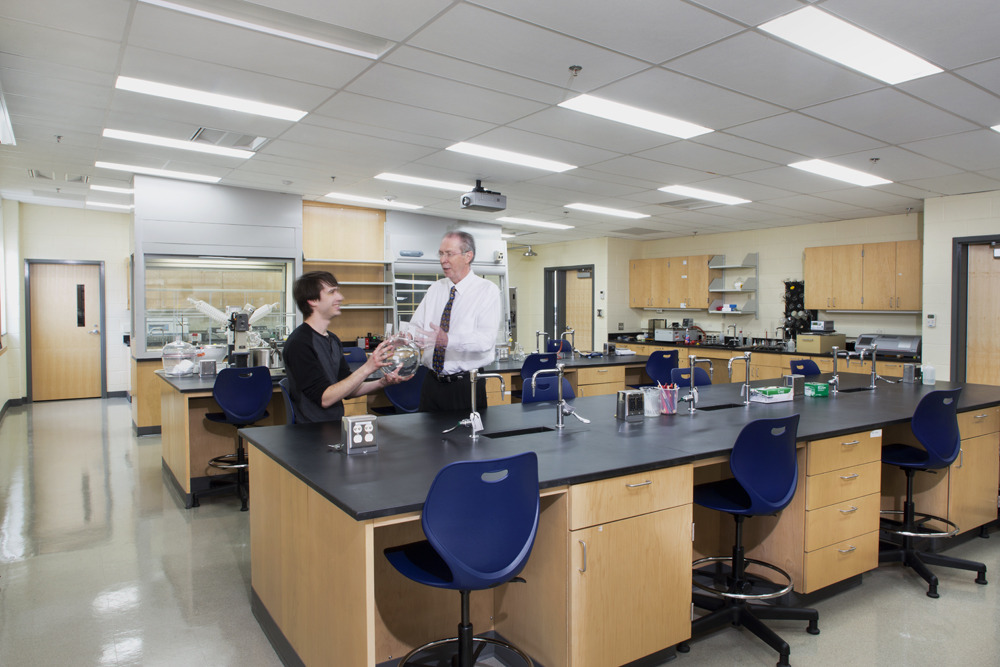 CMW_2015_002_N40_medium A bright laboratory with various lab equipment, and a student and professor talking at a lab table.