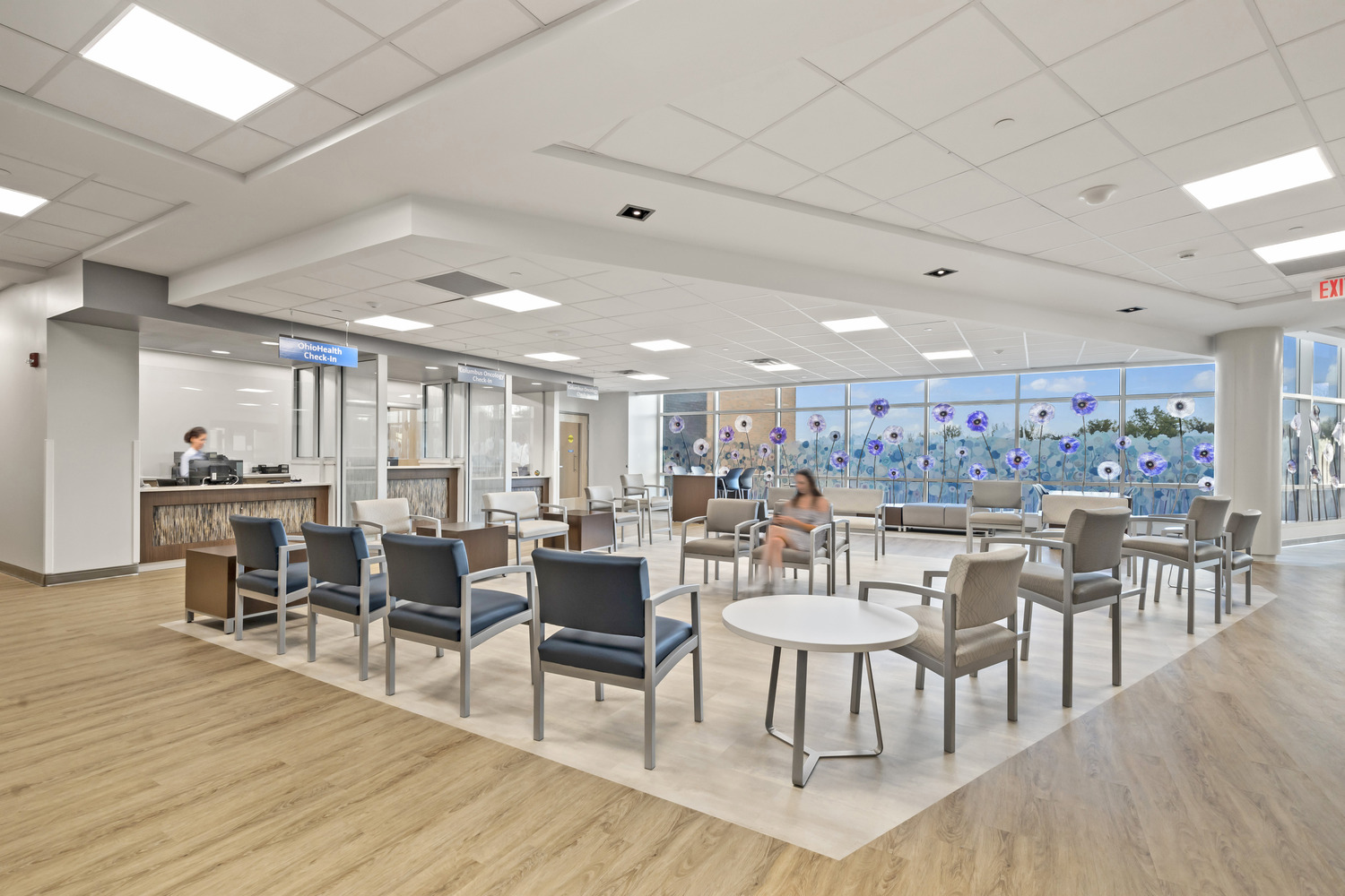 Westerville Cancer Center's waiting area, encircled by check-in counters and a wall of windows with floral decorations.