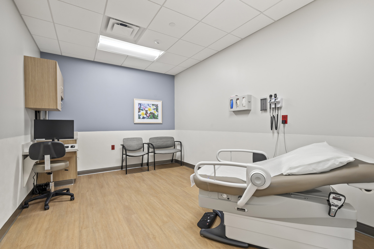 An exam room at Westerville Cancer Center with an exam chair and a soft blue accent wall.