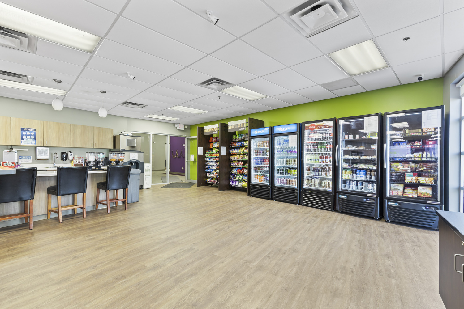 Vending machines and a high counter with chairs in the breakroom at Solut! Offices and Manufacturing Facility.