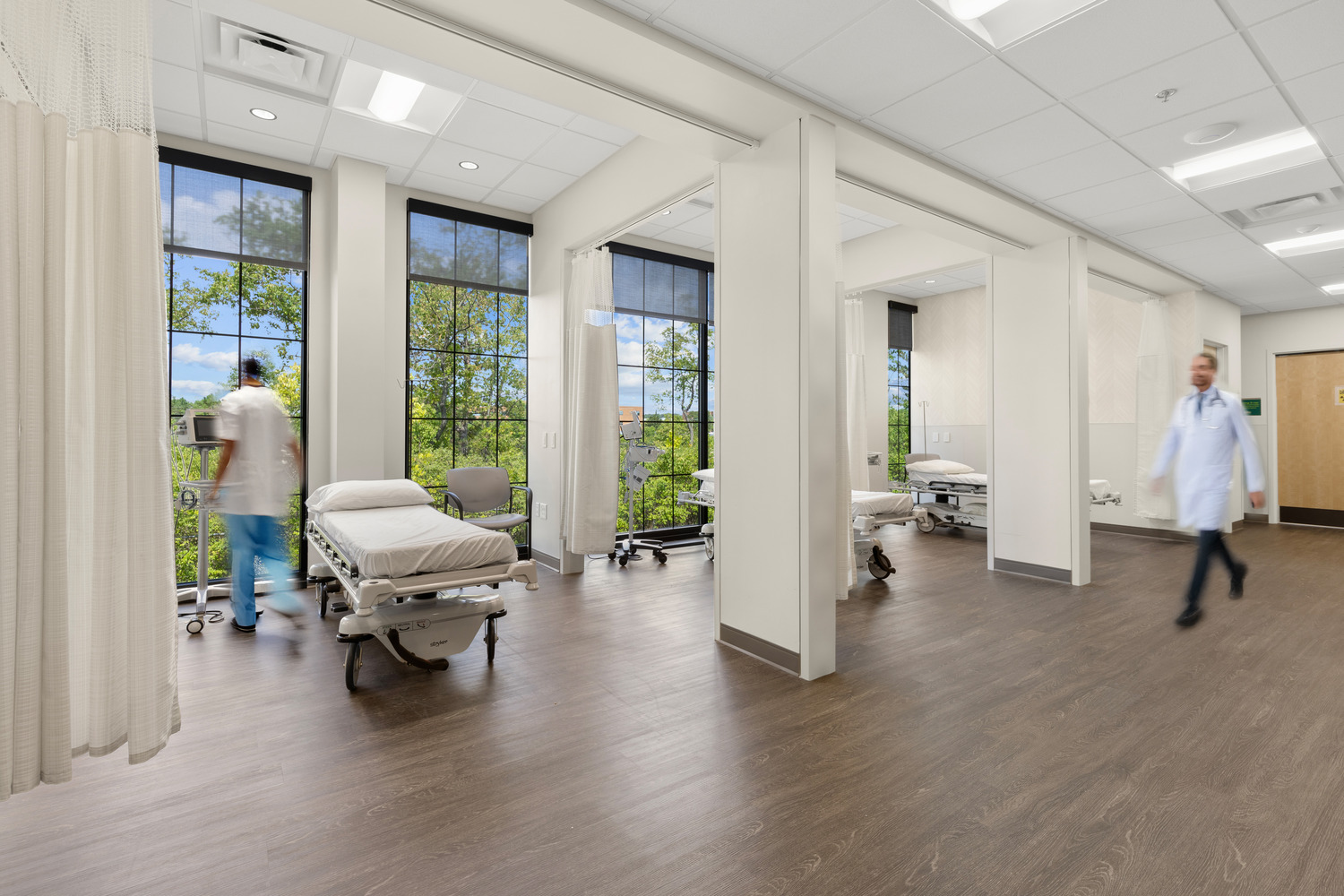 Medical professionals in four pre/post-op bays, each with a floor-to-ceiling windows at Vive Vascular.
