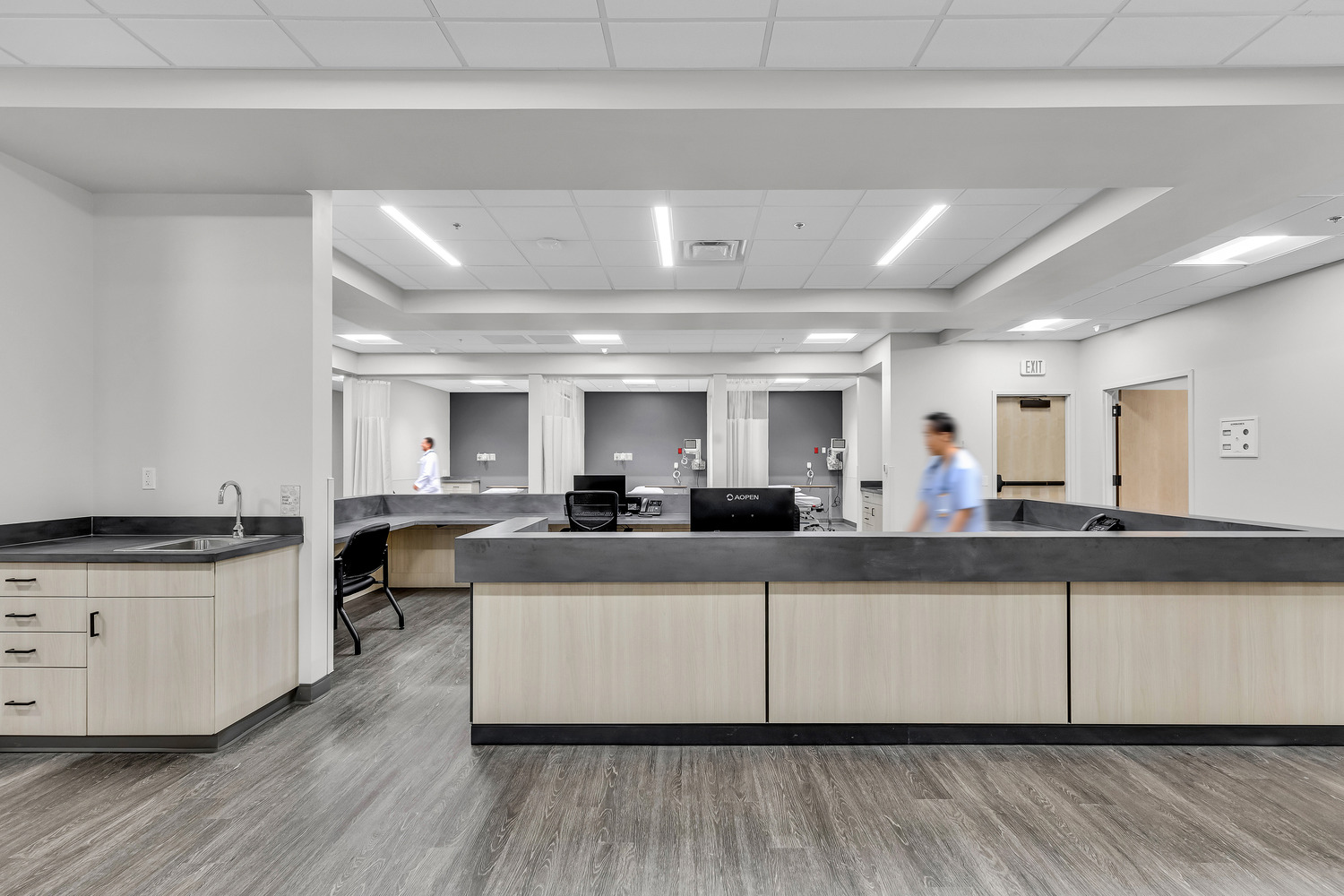 A spacious nurse's station in the foreground of the medical bays.