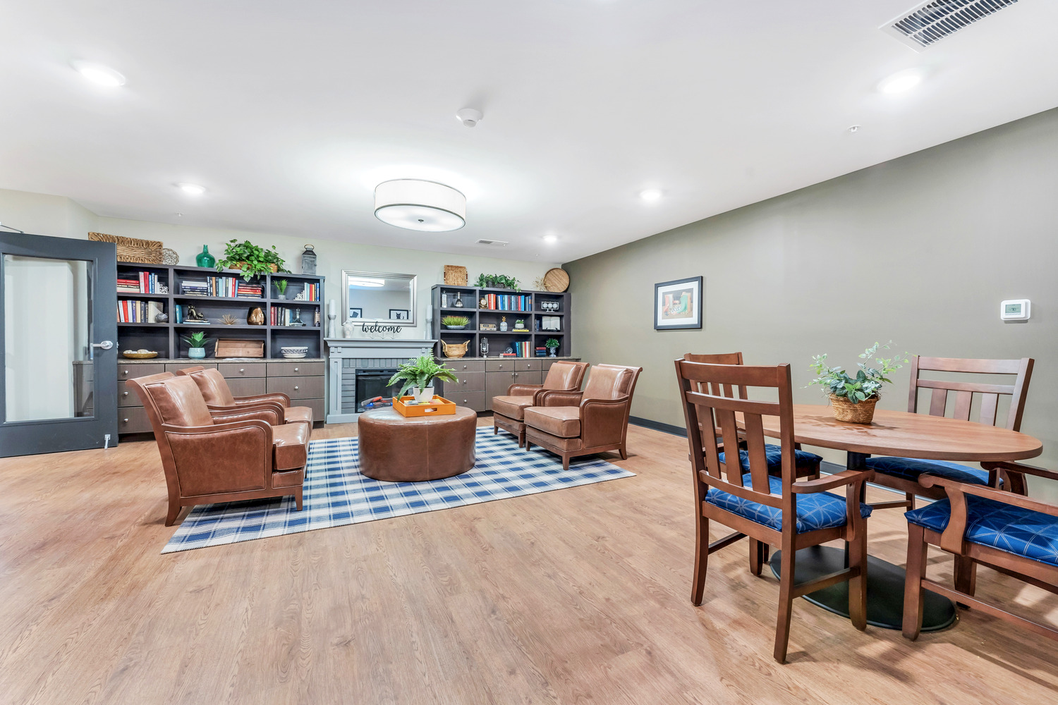 A common area in Homestead Village Active Senior Living Facility with a patterned blue rug, calming decorations, comfortable furniture.
