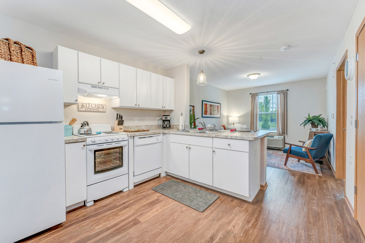 The kitchen of a Homestead Village Active Senior Living Facility unit with matching cabinets and appliances.