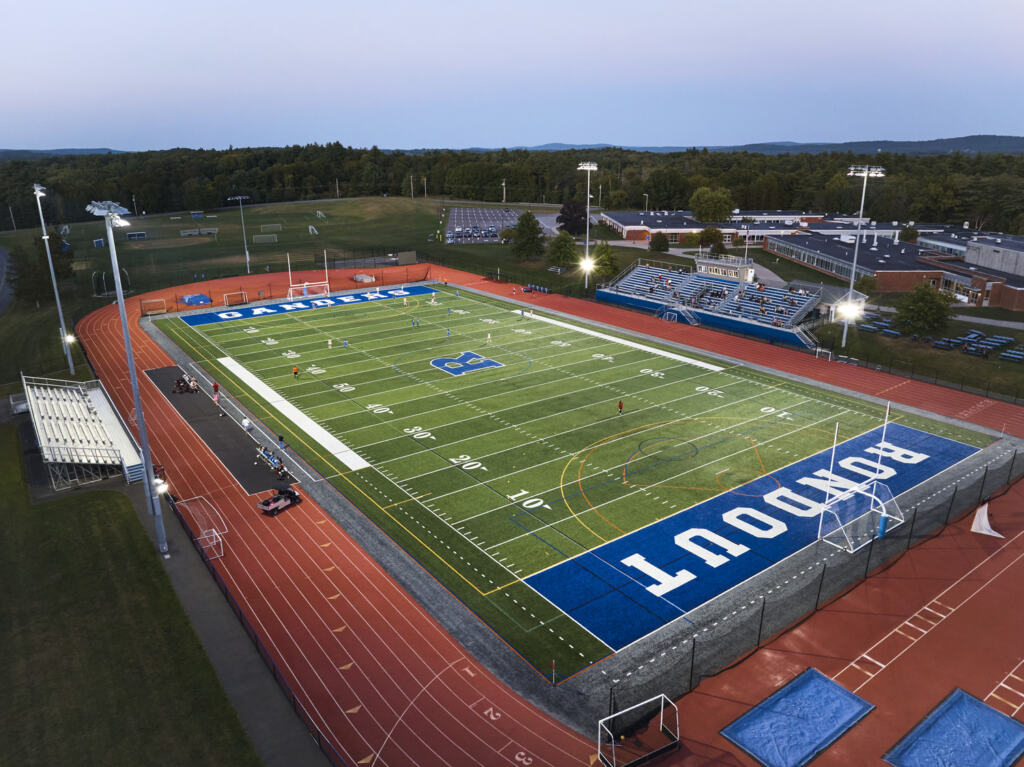 The Rondout Valley CSD Athletic Complex renovation at night, illuminated by stadium lights, on the academic campus.