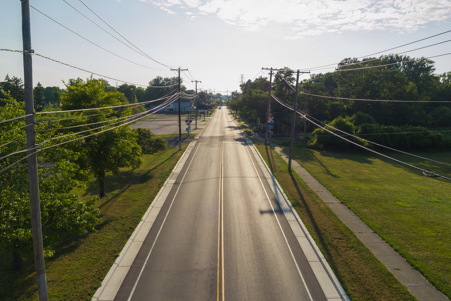 Erie County Dept of Public Works – Abbott Rd & Willett Rd Rehab Light shines on a smooth roadway between clean sidewalks as part of the Abbott Road and Willett Road rehabilitation.