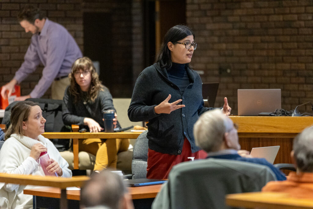 A CPL team member stands addressing a crowd at a Clarence Town Hall.