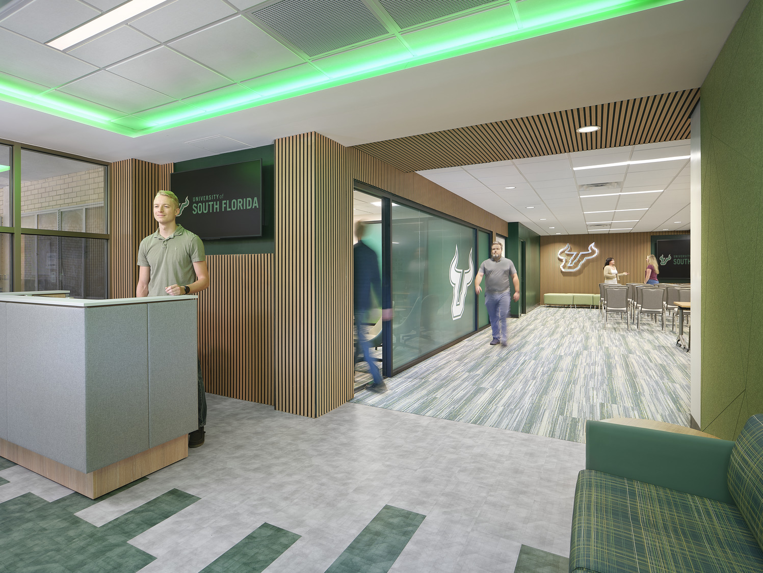 University of South Florida – Campus Visitation Center Entrance area and front desk of University of South Florida visitation center, the space decorated with shades of green, the USF logo, and green LED lighting strips.