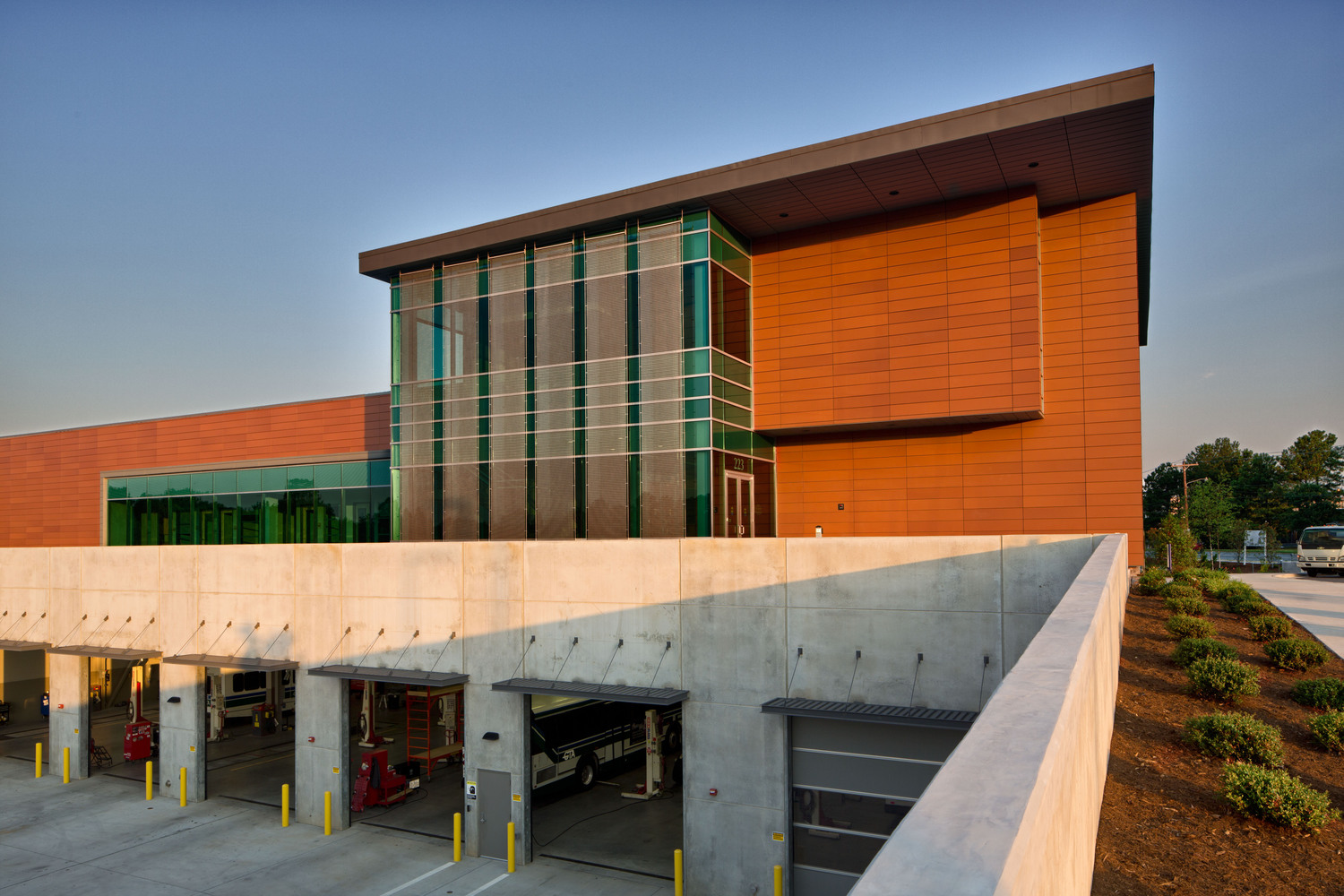 Warm, natural light hits the side of the Greensboro Transit Authority operations center's terracotta facade.