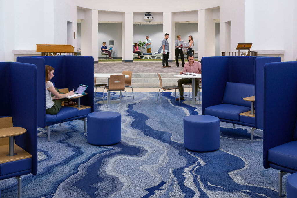 students are shown studying in large chairs and gathering in the distance of this room at St. Bonaventure University's School of Health Professions.