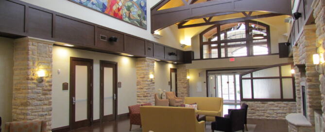 Senior center facility design featuring a bright, hospitality-inspired common area with natural light, warm materials and comfortable seating that supports connection and independence.