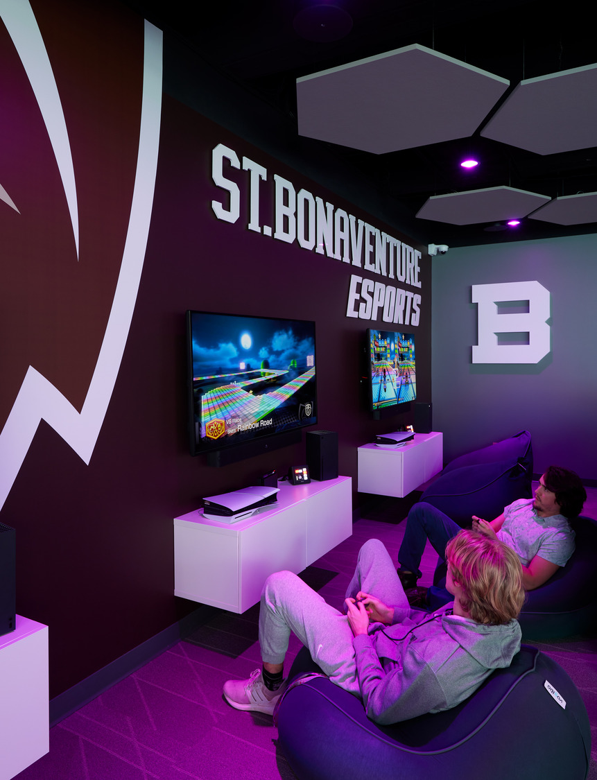 Two students sit back in beanbag chairs with game controllers in a practice corner of the St. Bonaventure University ESports Suite.