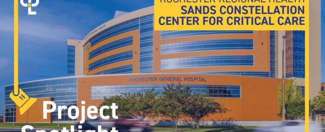 Alt text: "A modern hospital building with a curved facade under a blue sky, labeled 'Rochester General Hospital'. Foreground text reads 'Project Spotlight', 'Rochester Regional Health', and 'Sands Constellation Center for Critical Care', with a graphic of a spotlight and the CPL logo. Vegetation and a moving car are visible in front."