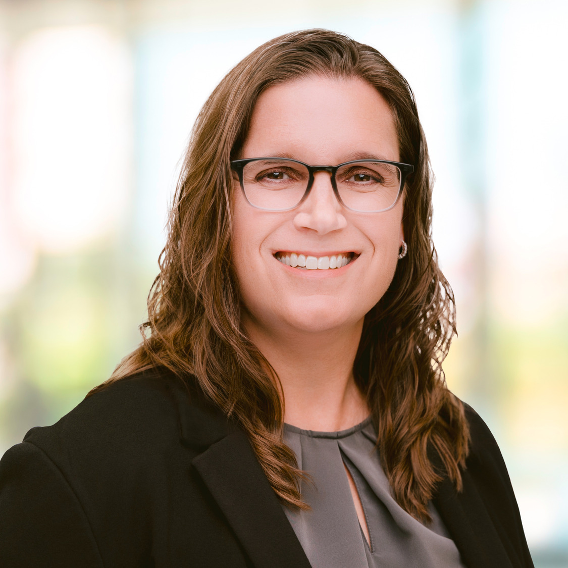 Smiling woman with brown hair and glasses on grapheen background