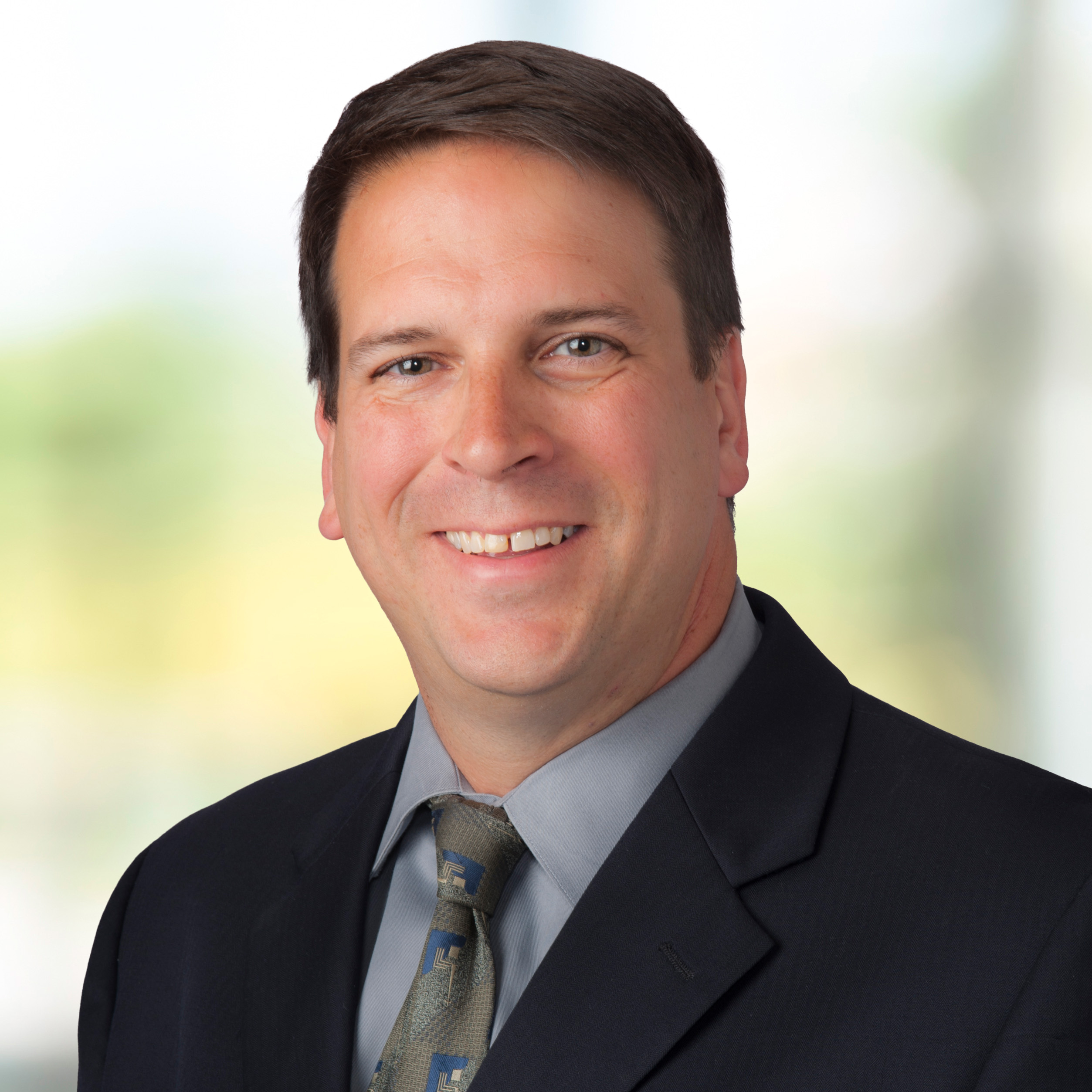 R_260326_Doug_Spies_LoQual_Headshots_N2 Doug Spies - in blue shirt with tie smiling on green background