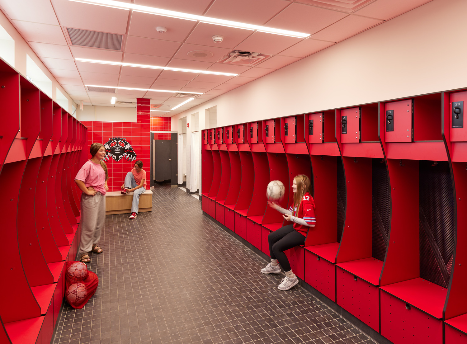 Students chat and tie their shoes in Bolivar Richburg's renovated vibrant red locker rooms.