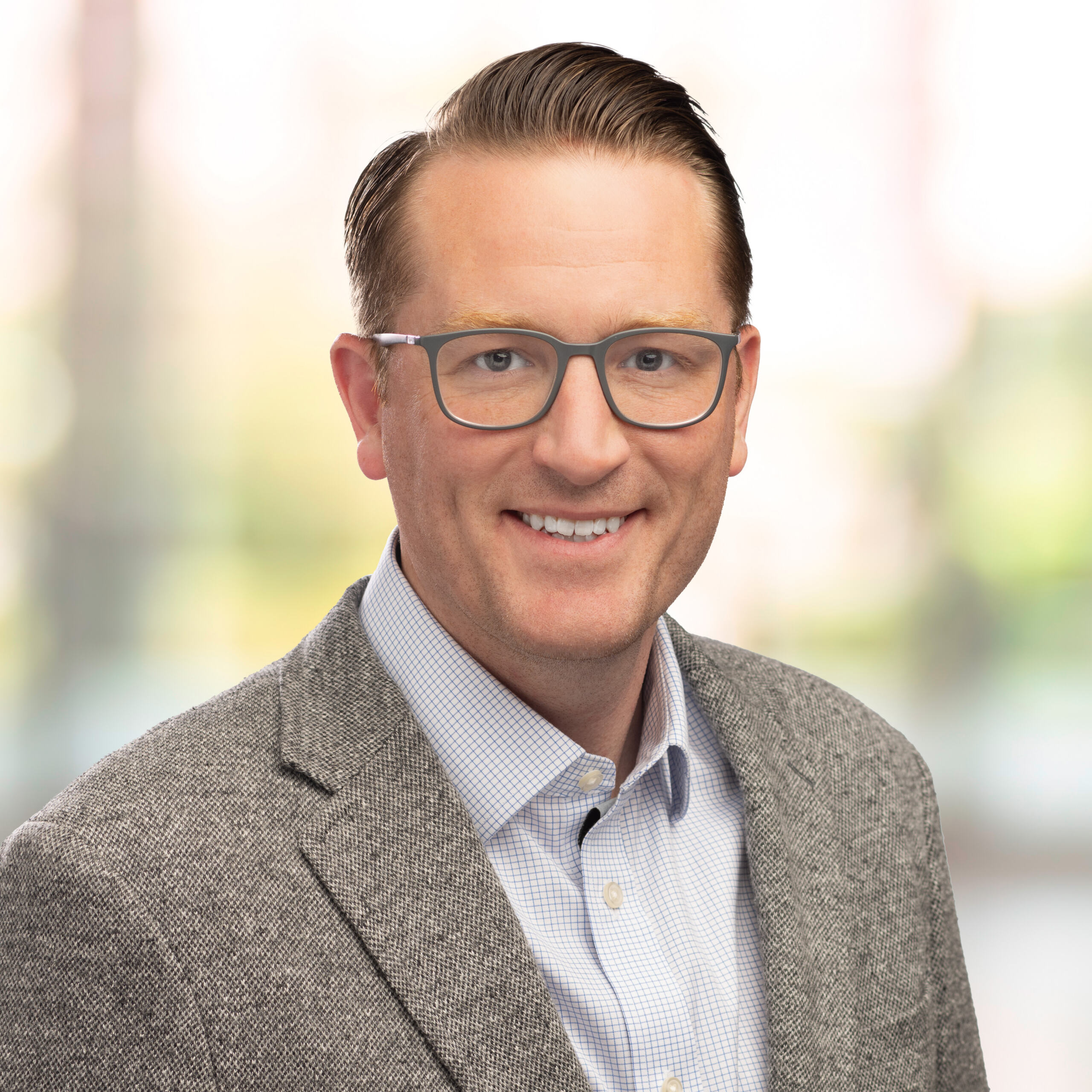 Smiling man in glasses on green natural background