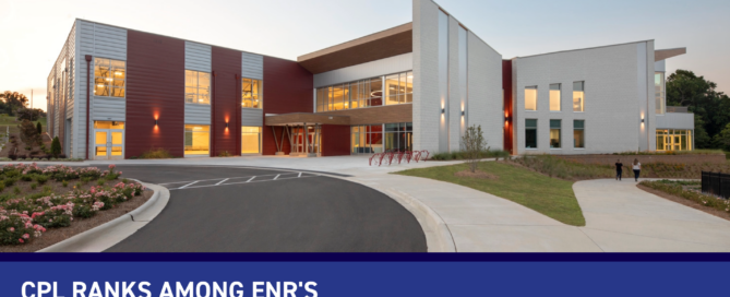 Exterior of a community center with vibrant red accents, and a blue banner announcing CPL's ENR Top 500 Design Firms placement.