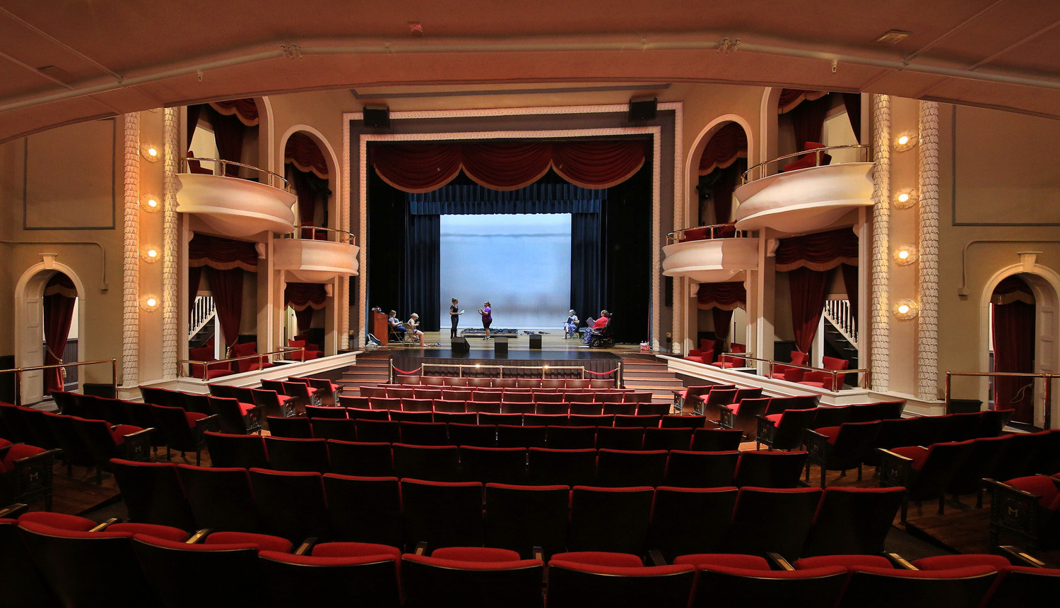 Theatre rehabilitation at the Historic Masonic Theatre featuring red velvet seating, ornate balconies, and a restored stage framed by classic curtains.