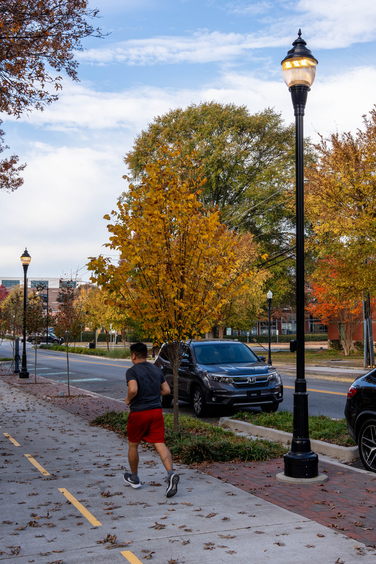 A man running on a designated walking and biking path on an autumn day in Chamblee, GA.