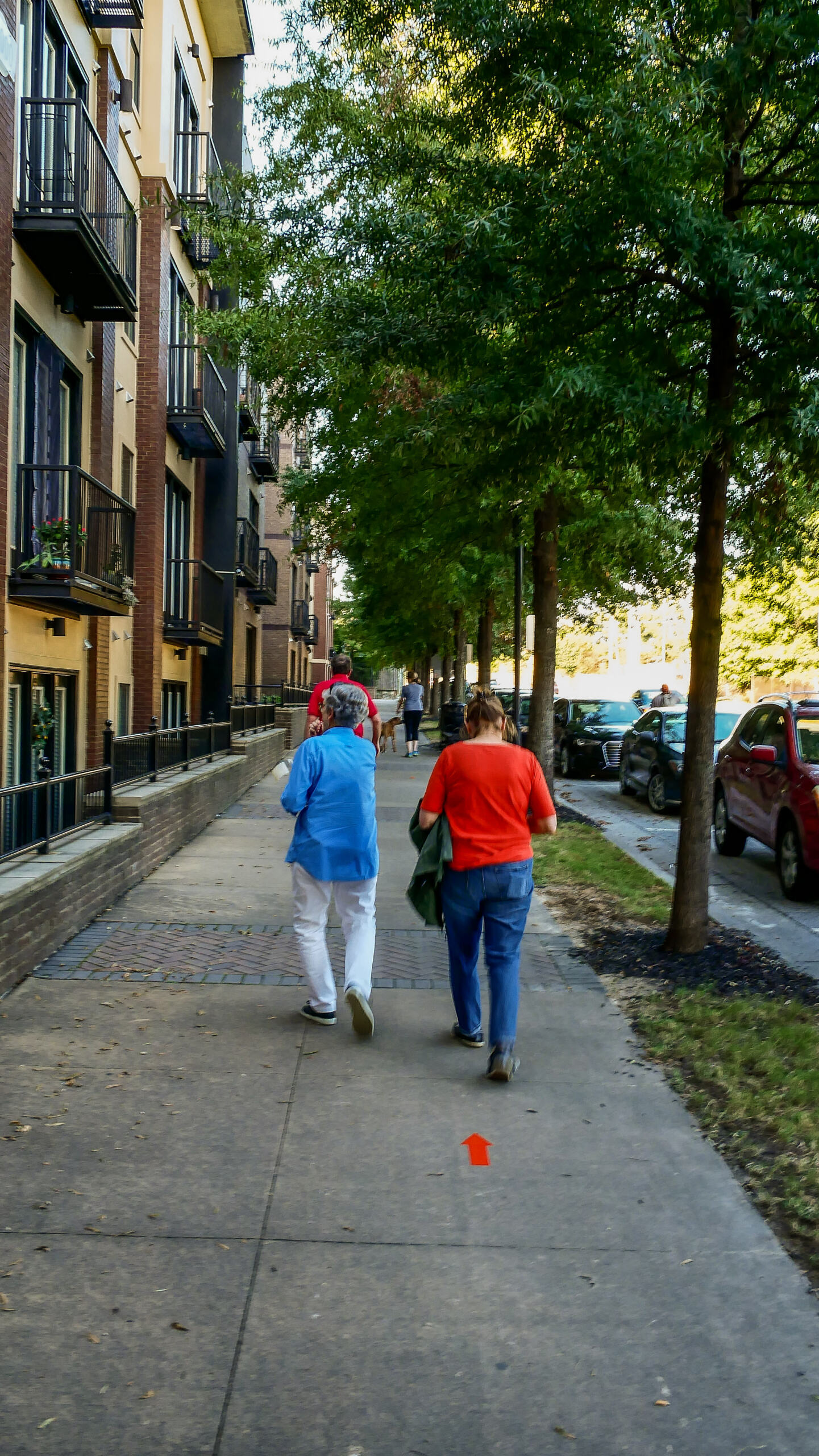Two people stroll along a sidewalk in a walkable city, Chamblee, GA.